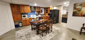 a kitchen with a table and chairs and a refrigerator at Logis dans un Sous sol au Mont Video in Barraute