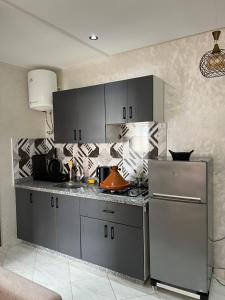 a kitchen with gray cabinets and a counter top at Oualidia city in Oualidia