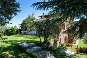 a stone house with a garden and a tree at mikipongTWO in Montepulciano