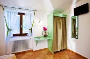 a room with a window and a table with a vase of flowers at Affittacamere Le Querce in Fiano Romano