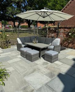 a patio with a table and an umbrella at Church Farm Dairy in Whissonsett +54 photos