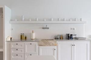 a kitchen with white cabinets and a counter top at Thavma Boathouse in Firopótamos