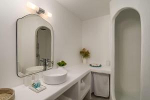 a white bathroom with a sink and a mirror at Thavma Boathouse in Firopótamos +8 photos