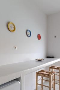a white table with three clocks on the wall at Thavma Boathouse in Firopótamos