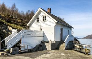 a small white building with stairs next to a body of water at Kyrping Ferieplass A in Kyrping