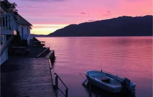 a boat sitting on the water next to a dock at Kyrping Ferieplass A in Kyrping +6 photos