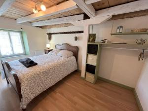 ein Schlafzimmer mit einem Bett in einem Zimmer mit Holzdecken in der Unterkunft La Chaumière in Saulxures-sur-Moselotte