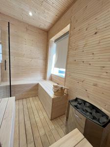 eine Holzsauna mit einer Badewanne und einem Fenster in der Unterkunft La Chaumière in Saulxures-sur-Moselotte