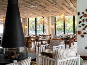 a restaurant with tables and chairs and a fireplace at The Nici in Bournemouth
