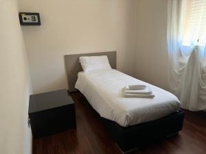 a small bedroom with a bed with two towels on it at Vittoria apartment - near outlet in Noventa di Piave