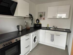 a white kitchen with a sink and a washing machine at Charmante Zentrale 2 Raum Wohnung in Chemnitz