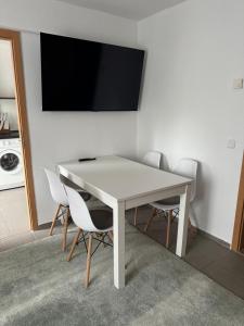 a white table with chairs and a television on a wall at Charmante Zentrale 2 Raum Wohnung in Chemnitz
