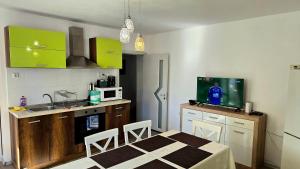a kitchen with a table and a kitchen with green cabinets at Grand Apartment Pomorie in Pomorie +15 photos