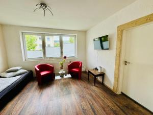 a bedroom with red chairs and a bed and a window at Sollstedt Ferienwohnung in Sollstedt