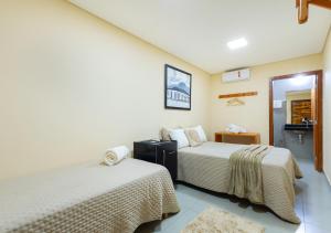 a hotel room with two beds and a bathroom at Hotel Santa Maria in Pirenópolis