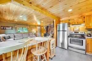 a kitchen and living room with a couch and a stove at Rustic Cabin in West Danville with Deck and Fire Pit! in West Danville