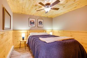 a bedroom with a bed and a ceiling fan at Rustic Cabin in West Danville with Deck and Fire Pit! in West Danville