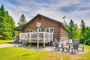 a log cabin with chairs and a table at Rustic Cabin in West Danville with Deck and Fire Pit! in West Danville