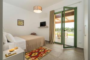 a bedroom with a bed and a sliding glass door at Cavalè in Menfi