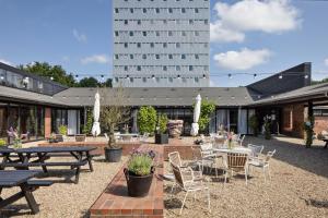 a patio with tables and chairs and a building at Højhuset Kulturhotel in Herning