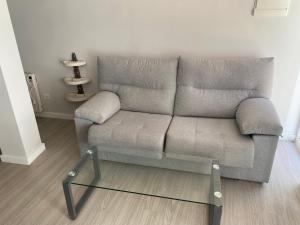 a gray couch in a living room with a glass table at Panxón Primera Linea Mar in Nigrán +10 photos