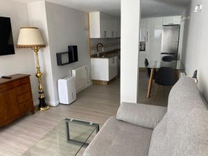 a living room with a couch and a kitchen at Panxón Primera Linea Mar in Nigrán