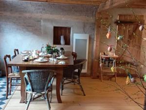 a dining room with a wooden table and chairs at La grange d'Ernest in Wittisheim