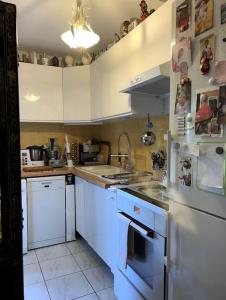 a kitchen with white cabinets and a stove top oven at Apparemment Blagnac proche TRAM in Blagnac +18 photos