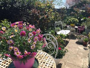 a garden with a table and chairs and flowers at Apparemment Blagnac proche TRAM in Blagnac