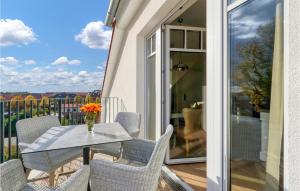 a glass table and chairs on a balcony with a view at Baltischer Hof Apartment 66 in Boltenhagen