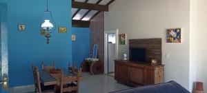 a living room with a table and a blue wall at Pousada Canto dos Passaros in Chapada dos Guimarães