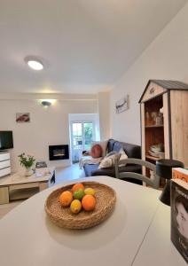 a living room with a bowl of fruit on a table at LE MISTRAL DU CENTRE VILLE ,chaleureux à 2 min de la plage in Dinard