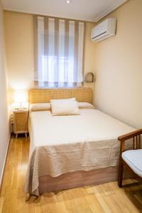 une chambre avec un grand lit avec une fenêtre dans l'établissement Encantador apartamento céntrico en Barrio Salamanca, junto a WiZink Center Movistar Arena y Plaza de Toros Las Ventas, à Madrid