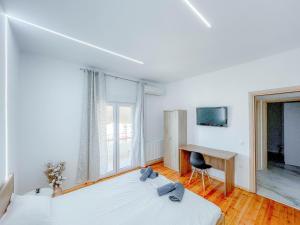 a white room with two beds and a desk at AYA Luxury Home - free public parking in Thessaloniki