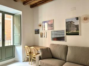 a living room with a couch and a table and chairs at CavaBajaSuites in Madrid