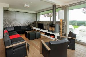 a living room with a couch and a fireplace at luxe vakantiehuis met panoramisch uitzicht Nisramont in La Roche-en-Ardenne