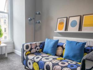 a living room with a couch with blue pillows at Pass the Keys West End Cosy Pop of Colour in Glasgow