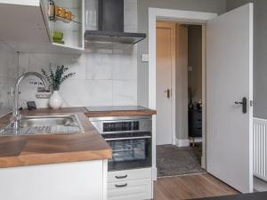a kitchen with a sink and a stove at Pass the Keys West End Cosy Pop of Colour in Glasgow