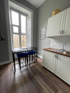 a kitchen with a table and chairs in a room at Pass the Keys West End Cosy Pop of Colour in Glasgow +27 photos