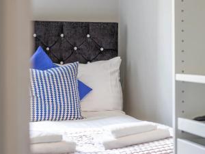 a bedroom with a bed with blue and white pillows at Pass the Keys West End Cosy Pop of Colour in Glasgow