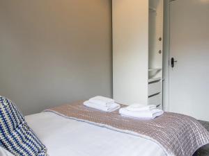 a bedroom with a bed with towels on it at Pass the Keys West End Cosy Pop of Colour in Glasgow