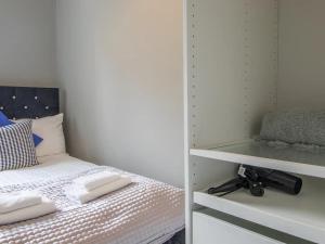 a bedroom with a bed with two towels on it at Pass the Keys West End Cosy Pop of Colour in Glasgow