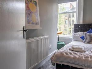 a bedroom with a bed and a window at Pass the Keys West End Cosy Pop of Colour in Glasgow