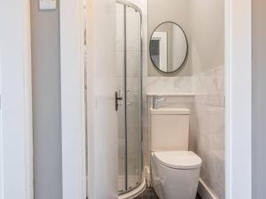 a bathroom with a toilet and a mirror at Pass the Keys West End Cosy Pop of Colour in Glasgow