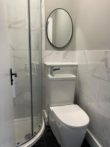 a bathroom with a white toilet and a mirror at Pass the Keys West End Cosy Pop of Colour in Glasgow