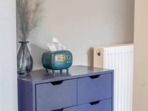 a blue cabinet with a green kettle on top of it at Pass the Keys West End Cosy Pop of Colour in Glasgow