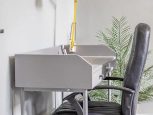 a white desk with a chair next to a plant at Pass the Keys West End Cosy Pop of Colour in Glasgow