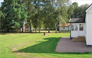 a house in a field next to a building at Holiday Home Björkvägen Höör in Höör