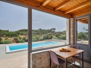 ein Esszimmer mit einem Tisch und Blick auf einen Pool in der Unterkunft Vine House in Isterni