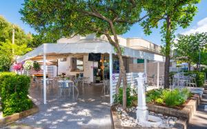 a restaurant with tables and chairs under a white tent at Camping Europa in Marina di Massa